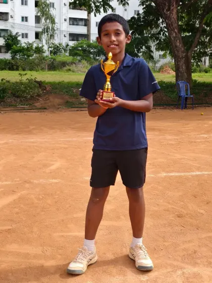A solo shot of Jaideep, our Under 10 winner, holding his trophy on the court. This is the result of consistent practice and a love for the game.