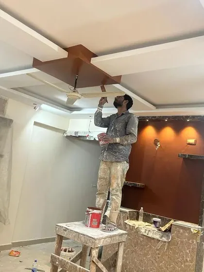One of our painters carefully working on a complex false ceiling design, showcasing the skill and attention to detail our team brings to every job.