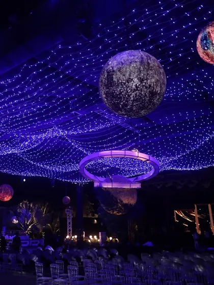 The view from the guest seating at the celestial Sangeet, showing the full effect of the starry sky ceiling and hanging planets. We design the entire space to be an immersive experience from every angle.