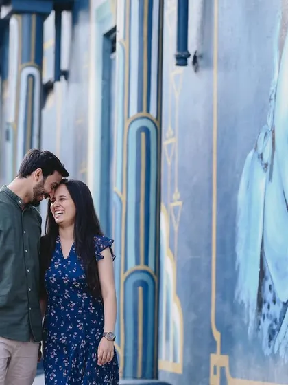 A candid moment of laughter against a striking blue mural. Urban shoots offer so many opportunities for color and texture, creating a vibrant setting for a couple's pre-wedding photos.
