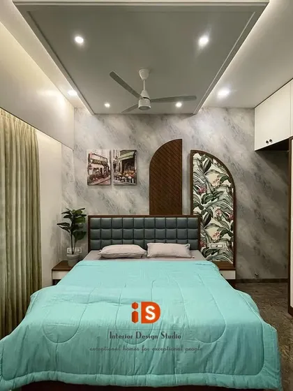 This "Go Green" themed guest bedroom combines nature-inspired elements with modern design. The room features a unique headboard with wood and tropical-print panels, a textured grey wall, and a sleek white sliding wardrobe that complements the theme.