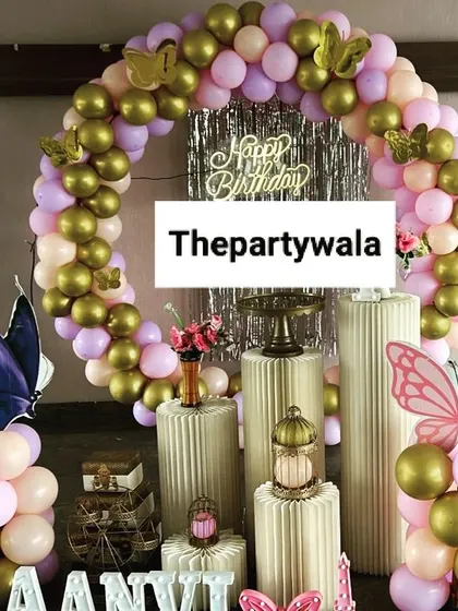 A simple and elegant butterfly theme with a ring of pastel and gold balloons.