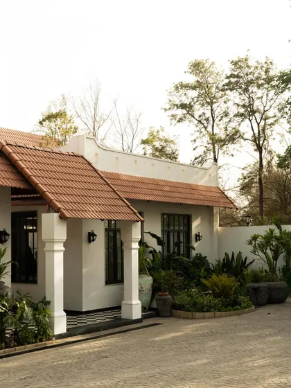 A wider view of the Elgin Cafe's facade, showing how the structure is nestled within its green surroundings. The architecture is quiet, privileging proportion and atmosphere over spectacle.