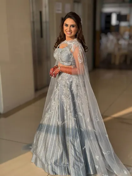 A full-length view of this stunning silver sangeet lehenga. The cape adds a touch of drama, and the makeup is kept chic and defined.