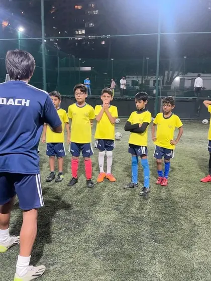 A coach gives instructions to the advanced U9 team. We challenge our more experienced players with complex drills and concepts.