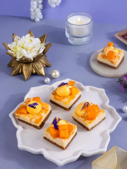 Delicate mango and coconut mini cheesecakes, decorated with edible flowers and pearls for an elegant, high-end look.