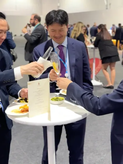 Guests toasting at a networking reception. We help create a celebratory and convivial atmosphere with our elegant service and premium beverage selections.