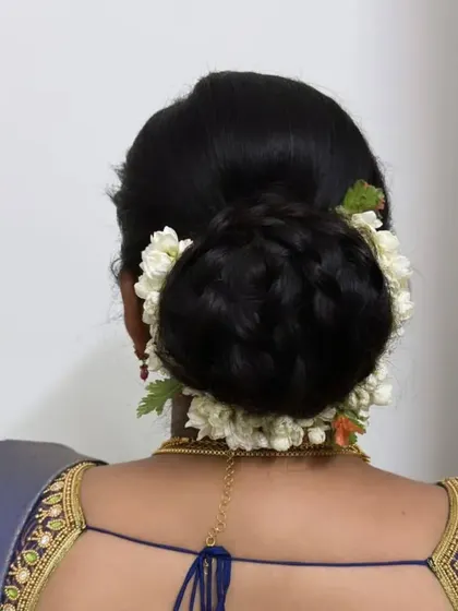 A braided bun wrapped in fresh jasmine, a beautiful and secure style that combines two classic techniques.