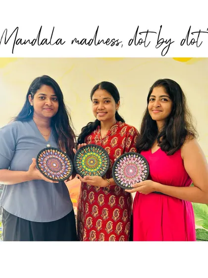 Three participants from a dot mandala workshop, each holding their unique and colorful plate.