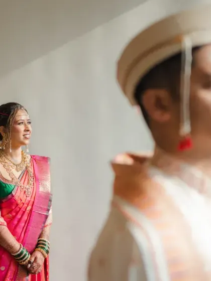 A beautiful first look portrait of the Marathi bride, with the groom in the foreground. The soft light and artistic composition create a sense of anticipation and romance.