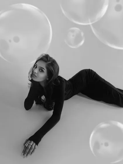 A soft and gentle black and white portrait. The model's relaxed pose and the dreamy bubble effect create a serene and beautiful image.