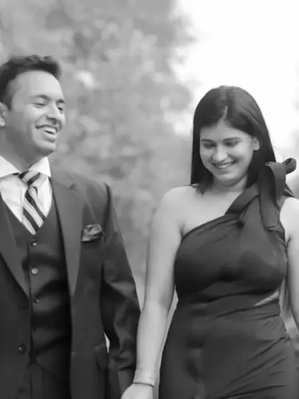 A candid black and white shot of a couple walking and laughing together during their pre-wedding shoot. This photo captures a genuine moment of joy and companionship.
