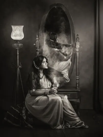 A creative, ethereal black and white portrait where a mother's reflection appears in a smoky haze in the mirror. This artistic shot plays with light and shadow to create a mysterious and beautiful image.