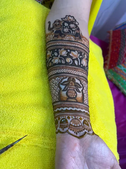 The arm section of a bridal mehndi, showing how we incorporate traditional elements like the elephant and kalash to complement the main portraits on the palm.