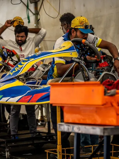 A glimpse into the focused environment of our pit garage. The team works diligently on a kart, making precise adjustments to the chassis and engine between races.