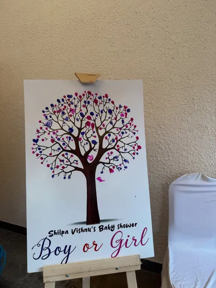 Another creative idea for a gender reveal: a "Boy or Girl" tree where guests can add their thumbprint "leaves" in blue or pink.