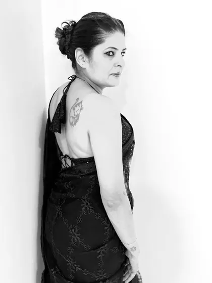 A monochrome shot of my black embroidered saree and backless blouse. The high contrast emphasizes the silhouette and the tattoo detail.