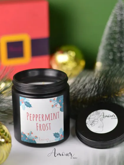 The 'Peppermint Frost' jar candle, perfect for a refreshing holiday scent. It comes in a sleek black jar with a festive botanical label.