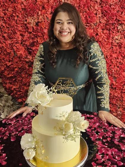 The art and the artist. Here I am, in my element, with a beautiful two-tiered white and gold floral cake I created for a friend's engagement.