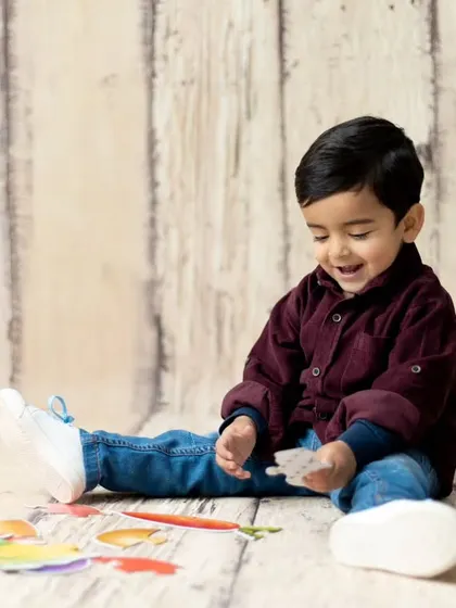 A candid moment of a toddler playing during his second birthday session. We incorporate playtime to keep children engaged and happy.