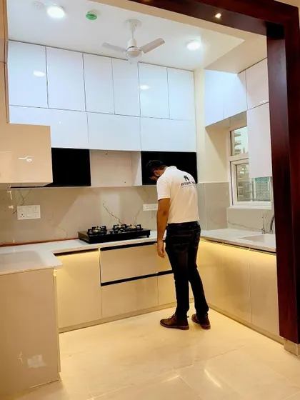 A final look at a U-shaped kitchen with a wooden archway. The white cabinets and light-colored countertop make the space feel bright and open, while the wooden frame adds a touch of warmth.