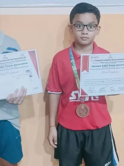 Nurturing talent from a young age. One of our junior players proudly holds his certificate and bronze medal, marking an important milestone in his competitive journey.