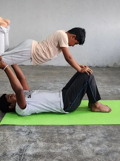 The concentration and strength required for this "flying" pose are evident, as the base supports the flyer with both hands and feet.