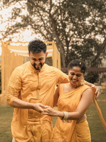 Sharing a dance in the rain during their Haldi ceremony. This is a perfect example of an unscripted, joyful moment that makes for an unforgettable memory.