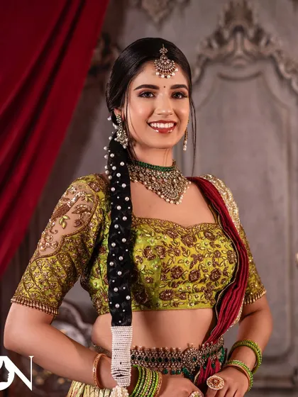 A smiling model looking radiant in a Kundan and pearl choker set. This is a great example of a non-bridal look that is still elegant and festive.