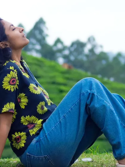 A serene moment, breathing in the fresh air of Munnar's tea gardens. This lifestyle image is perfect for wellness and relaxation themes.