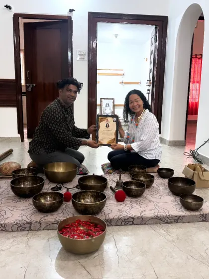 A student is awarded her certificate, a recognition of her commitment to learning the art of sound healing.