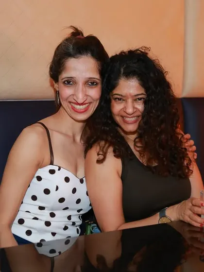 It’s not just about dancing! Two women smile for the camera while enjoying a drink, showcasing the social and community aspect of our Havana Nights.