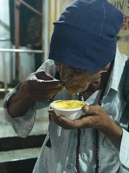 An elderly man finds nourishment and dignity in a simple, warm meal provided by our volunteers.