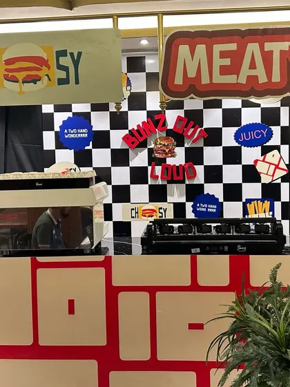 Another angle of the pop-up counter setup, featuring fun, quirky branding elements like "CHEESY" and "MEATY". We ensure every detail of the event space reflects the client's brand personality.