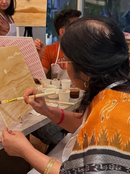 A participant at our coffee painting workshop, carefully adding details to her landscape. The warm, earthy tones of coffee create such a beautiful, rustic effect.