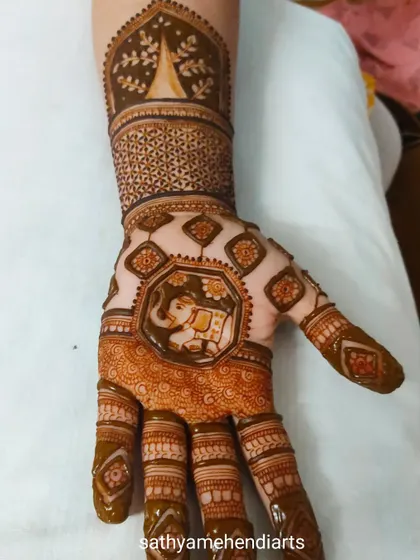 An intricate design featuring a majestic elephant at the center of the palm. The pattern is filled with detailed geometric and floral elements, perfect for a grand celebration.