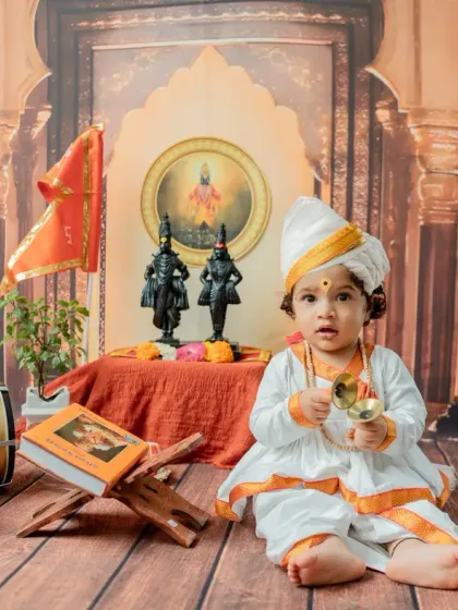 A calm and composed portrait of the baby seated with his cymbals, showcasing the beautiful details of the setup.