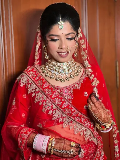 A smiling bride, looking confident in her traditional wedding attire.