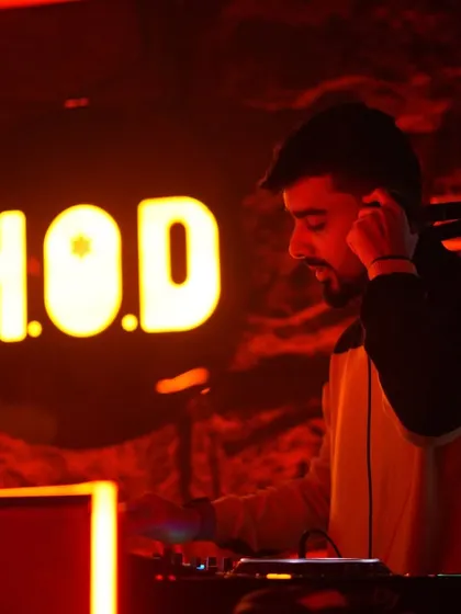 Adjusting my headphones at H.O.D. club, bathed in red light. It's in these moments of focus that I find the next track to keep the party going.