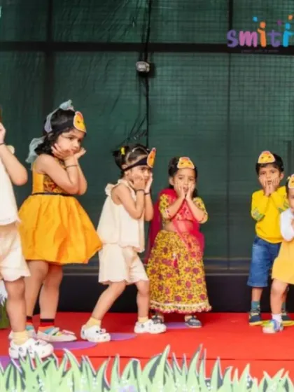 A group of girls in matching chick headbands perform an adorable dance. Their coordinated effort showcases the teamwork they learn at Smiti.