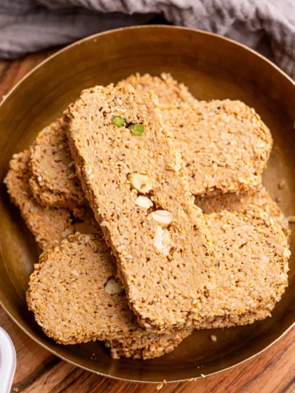 A close-up of my heart-shaped Gajak in a brass bowl. This traditional winter sweet is perfect for celebrating Makar Sankranti with love and warmth.