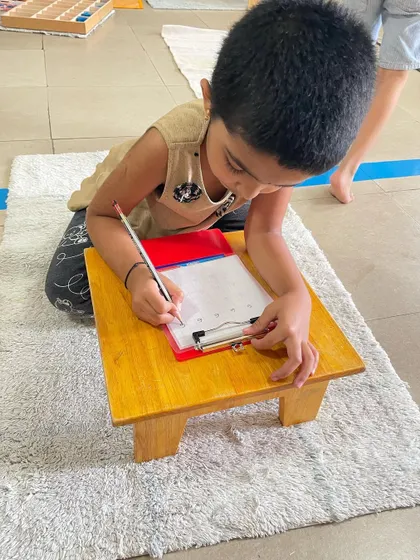 The journey to writing is a gradual process. Here, children practice forming letters and numbers, building on the fine motor control and concentration they have developed through countless practical life and sensorial activities.
