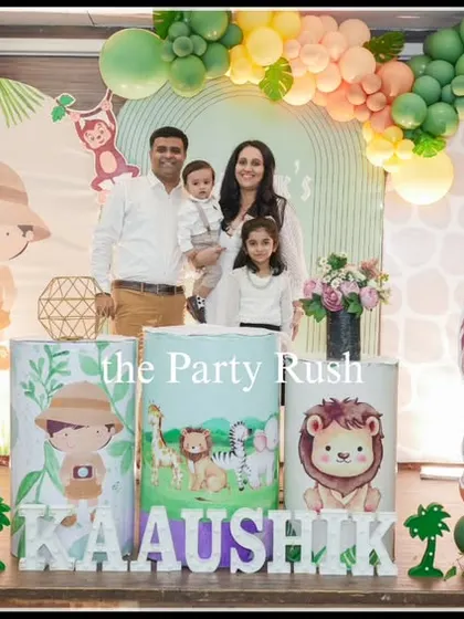 The whole family gathers for a photo at Kaaushik's "Wild One" birthday. This setup shows a complete scene with friendly animal cutouts, a custom backdrop, and themed pedestals, creating a perfect photo opportunity.