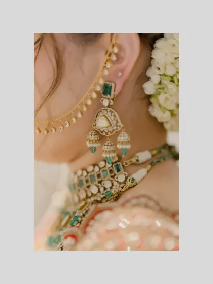 A detailed shot of the bride's jewelry, focusing on her beautiful emerald earrings and necklace.