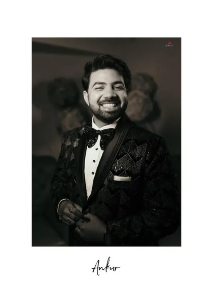 A handsome black and white portrait of the groom, capturing his joyful smile and sharp tuxedo on his engagement day.