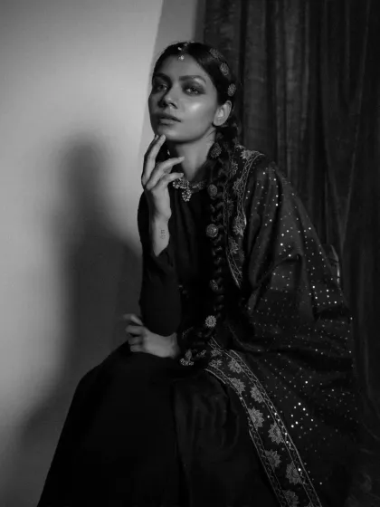 The black and white version of an 'Amodini' portrait. Stripping away the color emphasizes the textures of the fabric, the intricate jewelry, and the moody, cinematic lighting of the shot.