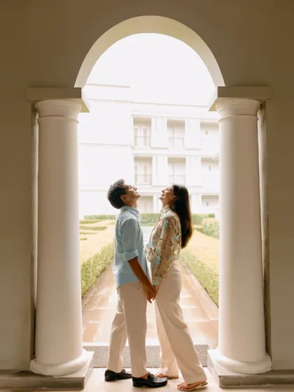 A silhouetted portrait of a couple holding hands under a grand archway in Udaipur. This composition highlights their connection and the beautiful architecture surrounding them.