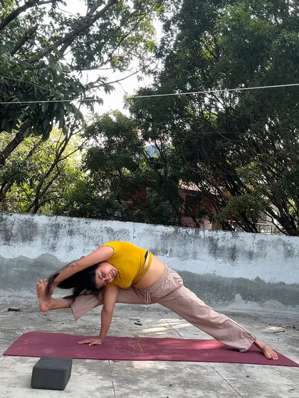 A challenging balancing pose, Visvamitrasana, practiced outdoors. This asana requires open hips, flexible hamstrings, and a strong core.