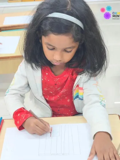 A student works diligently on her drawing, an example of how our individualized approach allows for deep focus and skill development.