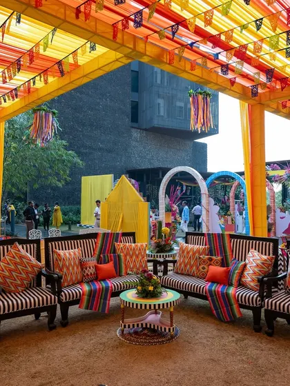 The vibrant seating area for a carnival-themed event, with striped and patterned cushions, colorful overhead draping, and a cheerful, festive atmosphere.